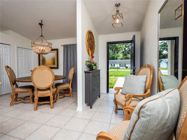 a kitchen with a dining table chairs and white cabinets