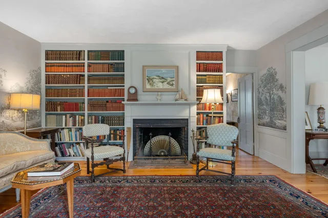 a living room with furniture a rug and a floor to ceiling window