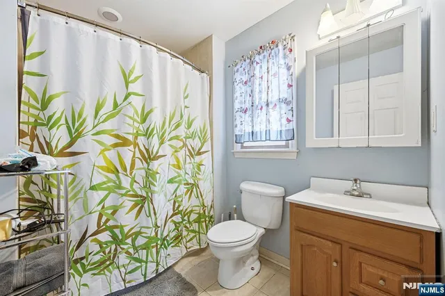 a bathroom with a sink a toilet and a shower curtain