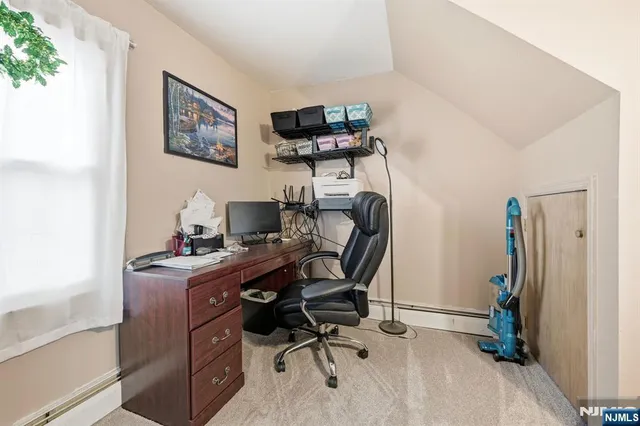a view of a workspace with furniture and a window