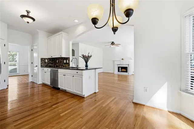 a kitchen with stainless steel appliances granite countertop a sink and wooden floors