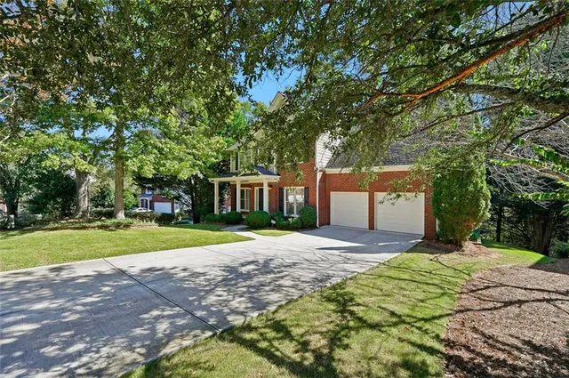 a front view of a house with a yard and trees
