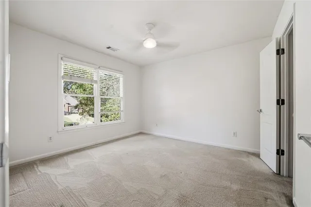 an empty room with a ceiling fan and a window