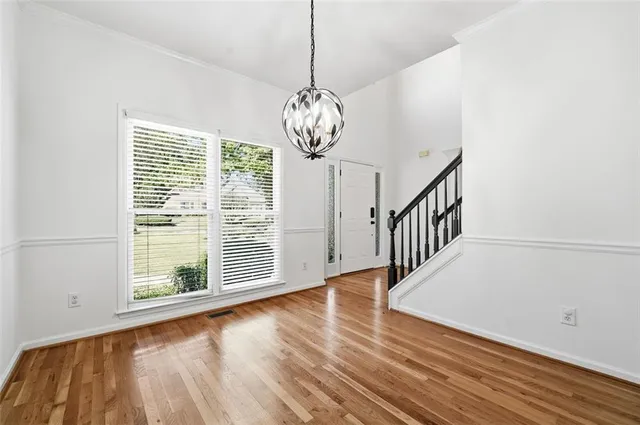 a view of a room with wooden floor fan and windows