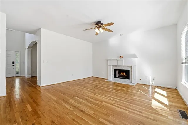 a view of a livingroom with a fireplace a chandelier and wooden floor
