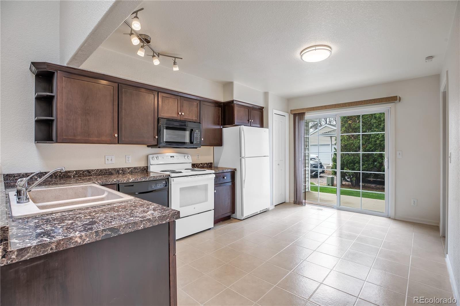 11690 West 46th Avenue Wheat Ridge, CO 80033 - Photo 10 of 33 a kitchen with a sink a counter top space cabinets and stainless steel appliances