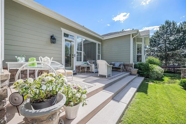 a view of a patio with chair and table potted plants