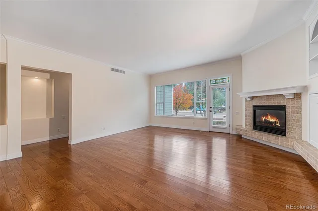 a view of an empty room with a window and fireplace