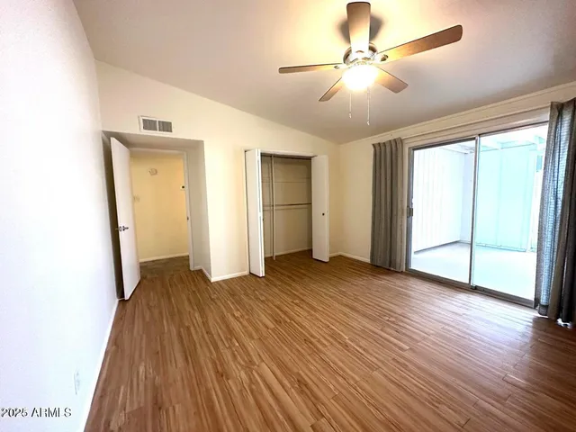 a view of a livingroom with wooden floor and a ceiling fan