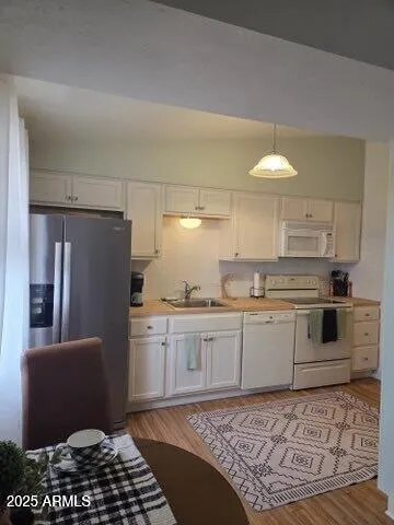 a kitchen with stainless steel appliances granite countertop a sink a stove a refrigerator and cabinets