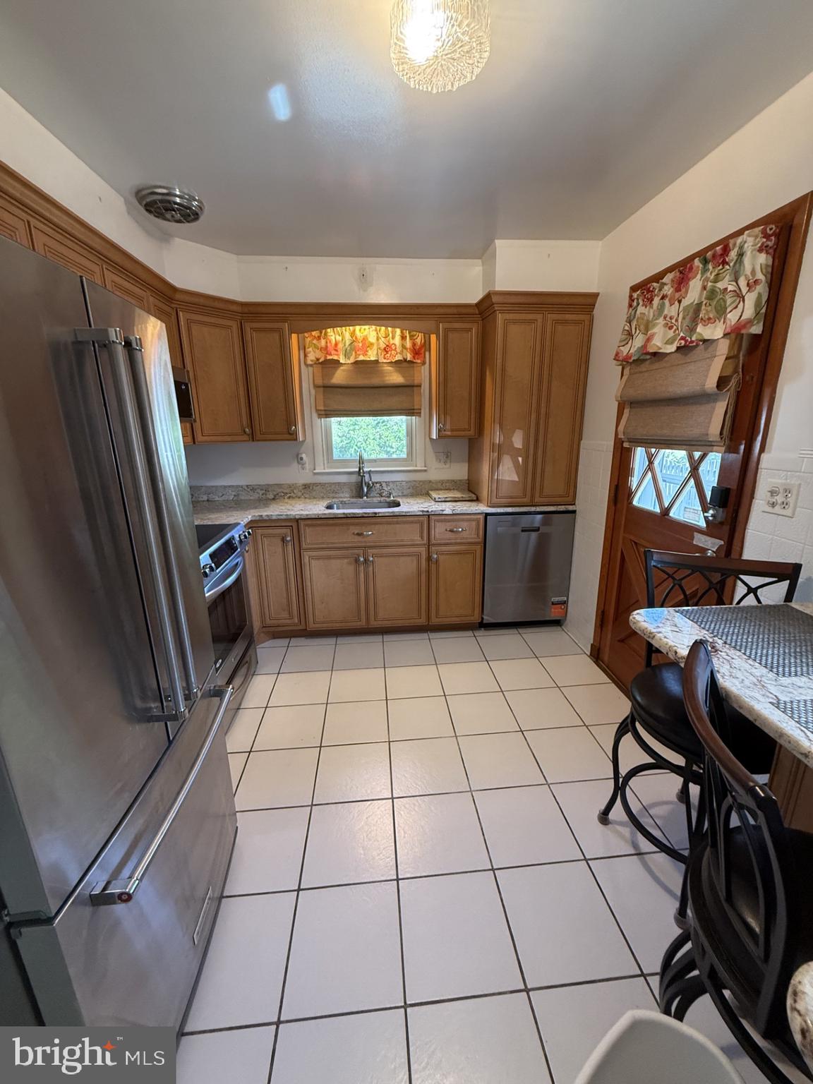 8806 Ashford Road Baltimore, MD 21234 - Photo 9 of 23 a kitchen with a sink a stove a microwave and cabinets