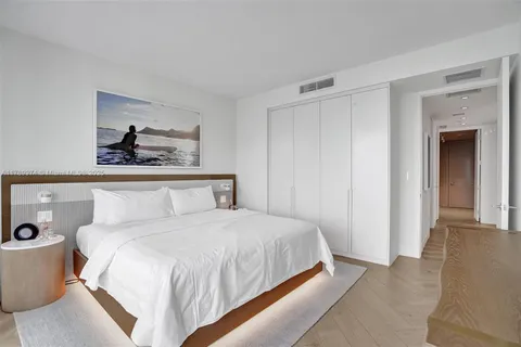 a bedroom with a large bed and a chandelier