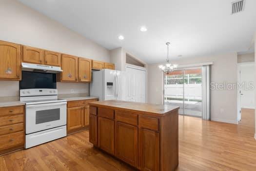 28 Karat Path Palm Coast, FL 32164 - Photo 11 of 75 a kitchen with stainless steel appliances kitchen island granite countertop a stove a sink and a refrigerator with wooden floors
