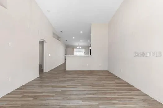 a view of an empty room with wooden floor