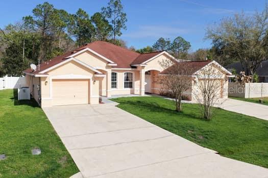 28 Karat Path Palm Coast, FL 32164 - Photo 64 of 75 a front view of a house with a yard and garage