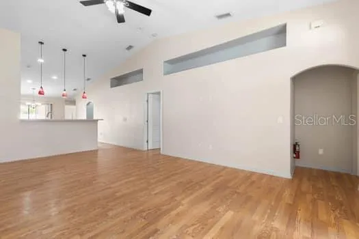 a kitchen with stainless steel appliances kitchen island granite countertop a stove a sink and a refrigerator with wooden floors