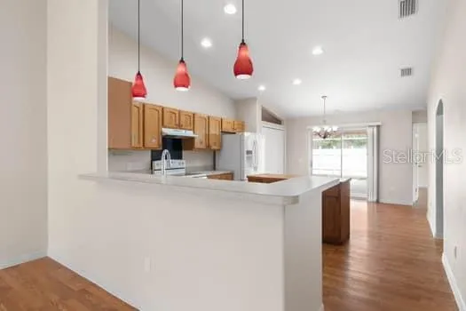 a kitchen with granite countertop a sink dishwasher a stove and a refrigerator