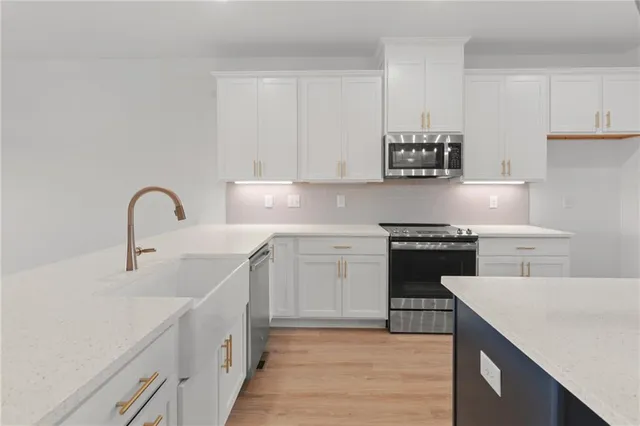 a kitchen with a sink cabinets and wooden floor