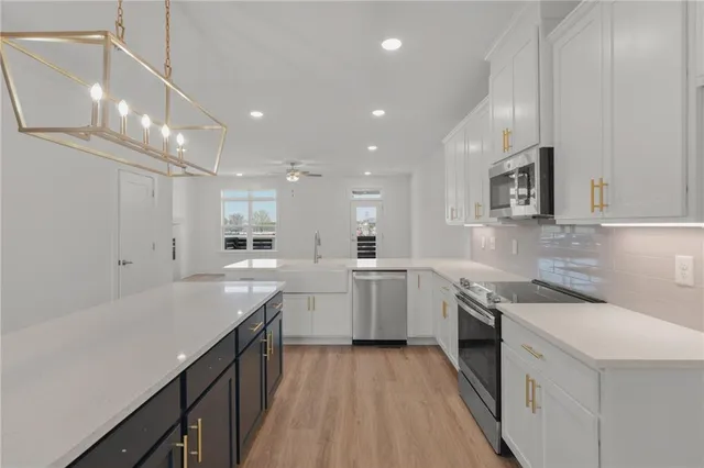 a kitchen that has a lot of cabinets in it and wooden floors
