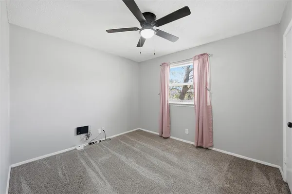 an empty room with closet and windows