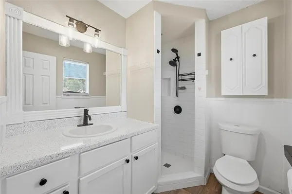 a bathroom with a sink a toilet and shower