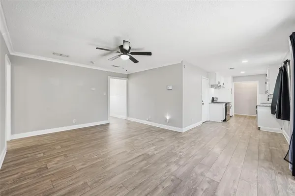 a view of empty room with wooden floor and window