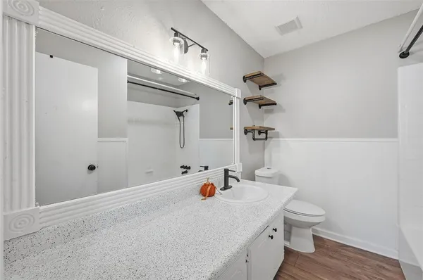 a bathroom with a sink a toilet and shower