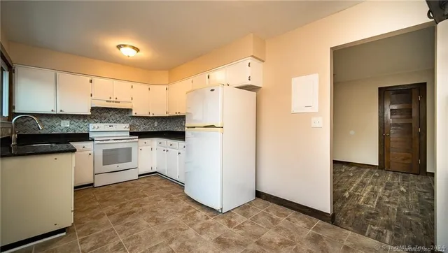 a kitchen with white cabinets and white appliances
