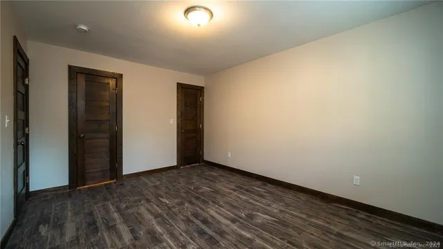 an empty room with wooden floor and closet
