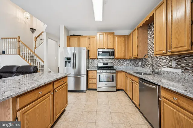 a kitchen with granite countertop a sink stainless steel appliances and cabinets