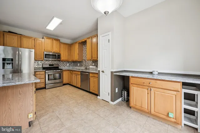 a kitchen with stainless steel appliances granite countertop a stove a sink dishwasher and a refrigerator