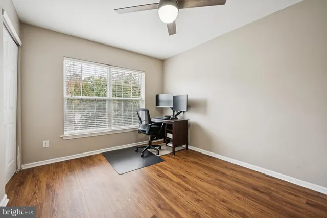 a view of a workspace with furniture and a window