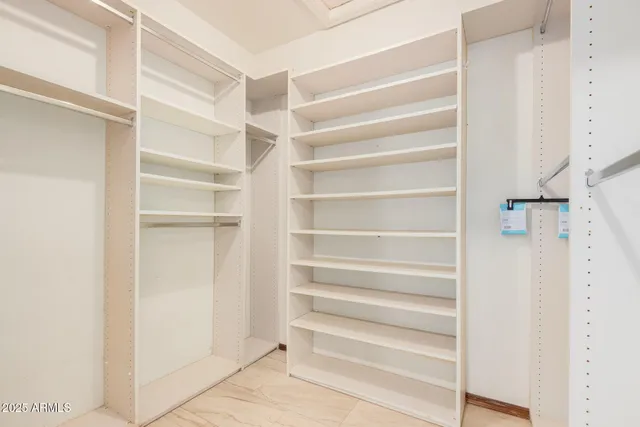 a view of walk in closet with empty racks
