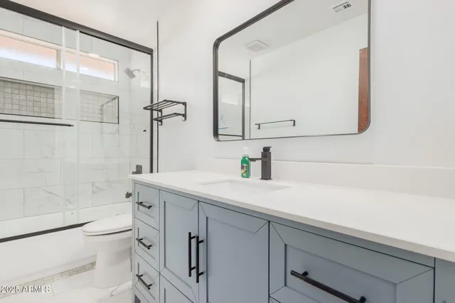 a bathroom with a sink a toilet and shower