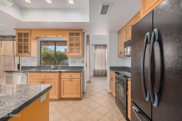 a kitchen with stainless steel appliances granite countertop a refrigerator and a sink