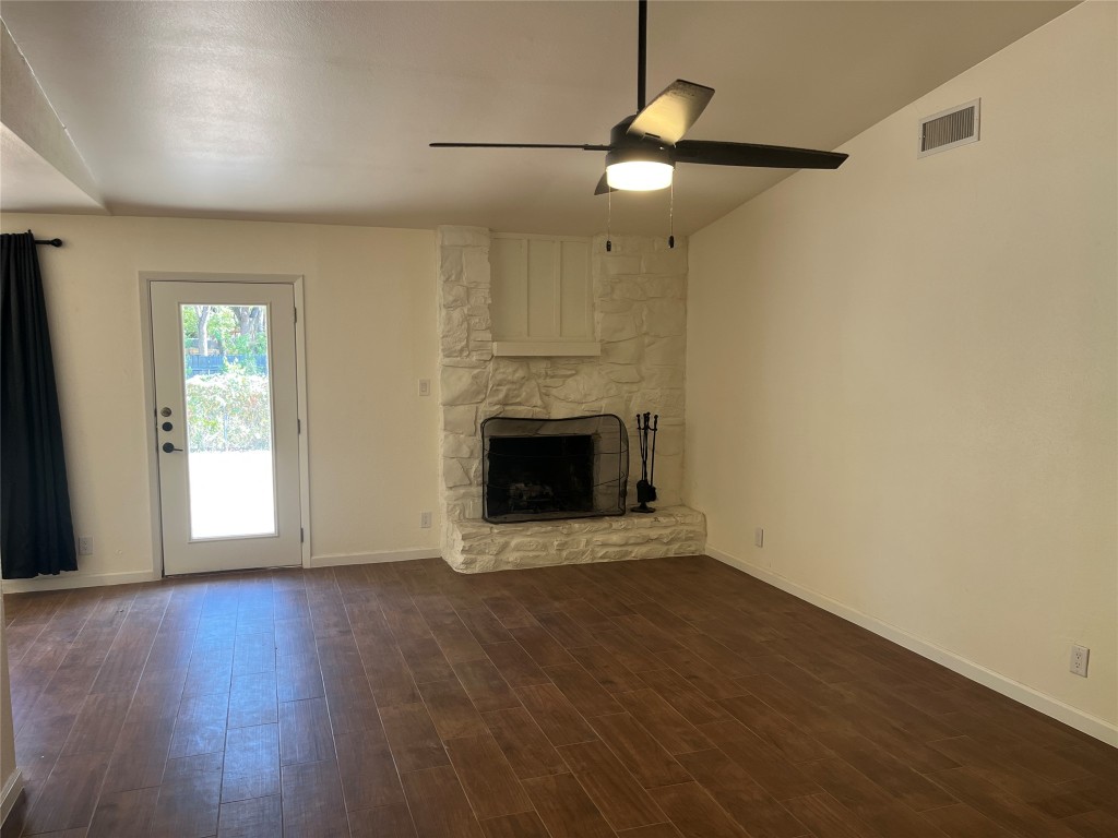 12119 Robin Ridge Lane Austin, TX 78750 - Photo 2 of 9 an empty room with wooden floor fireplace and windows