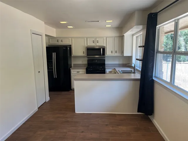 a view of kitchen with stainless steel appliances cabinets