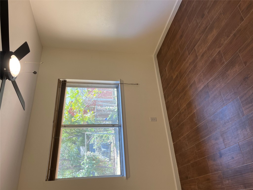 12119 Robin Ridge Lane Austin, TX 78750 - Photo 6 of 9 an empty room with wooden floor and windows