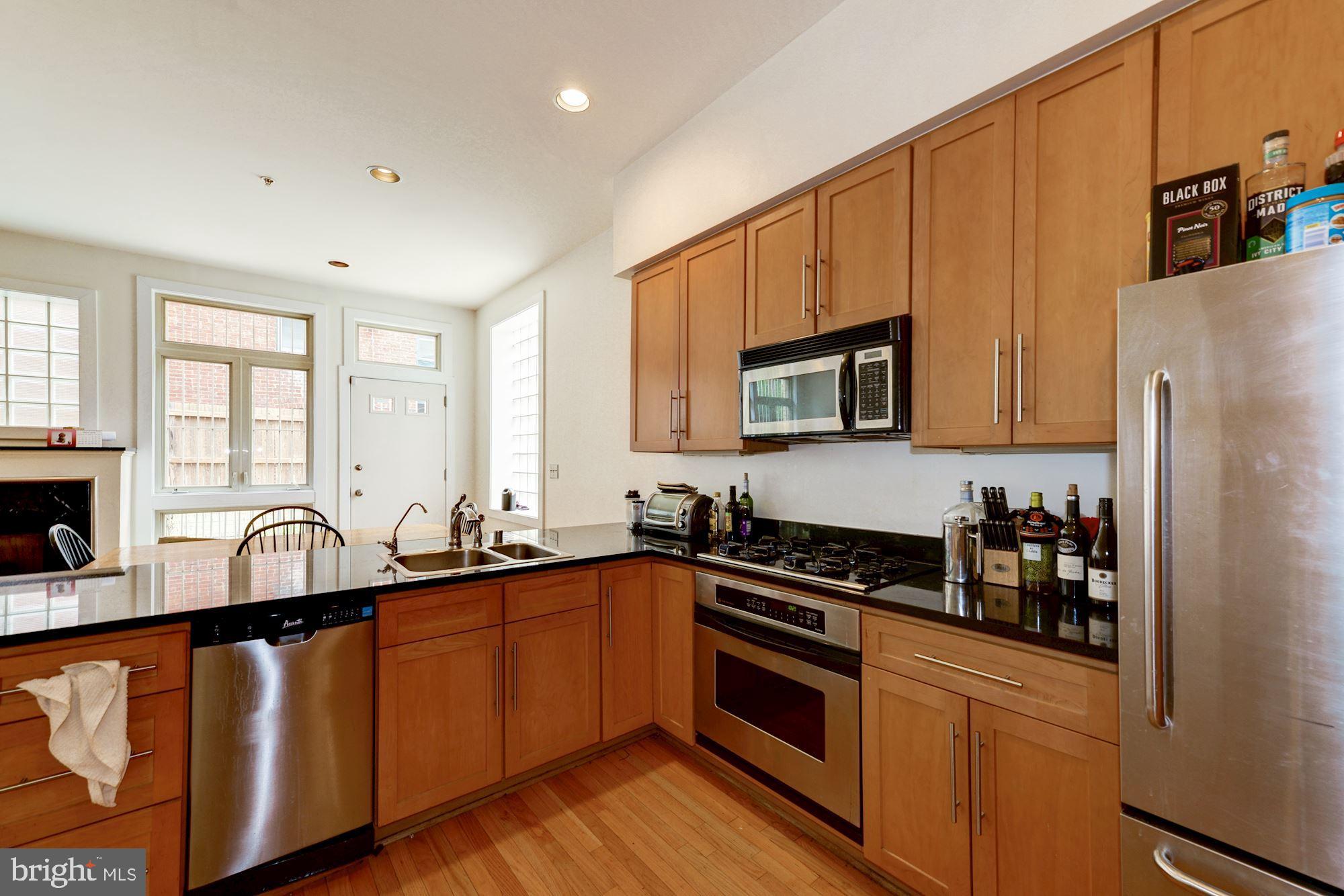 2363 Champlain Street Northwest, Unit 8 Washington, DC 20009 - Photo 9 of 30 a kitchen with granite countertop a sink stove and refrigerator