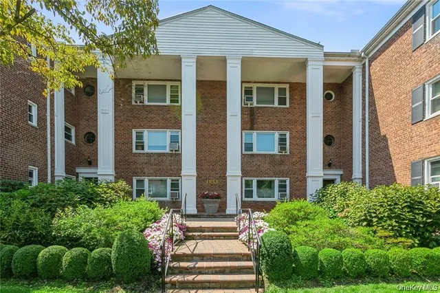 a front view of a brick house with a yard