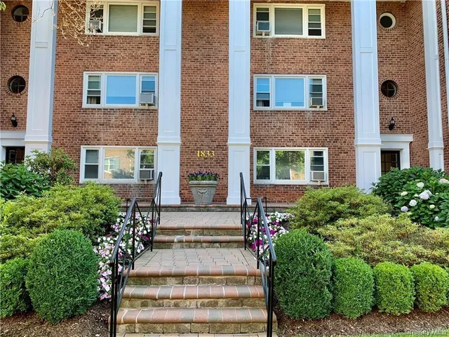 a front view of a house with stairs and windows