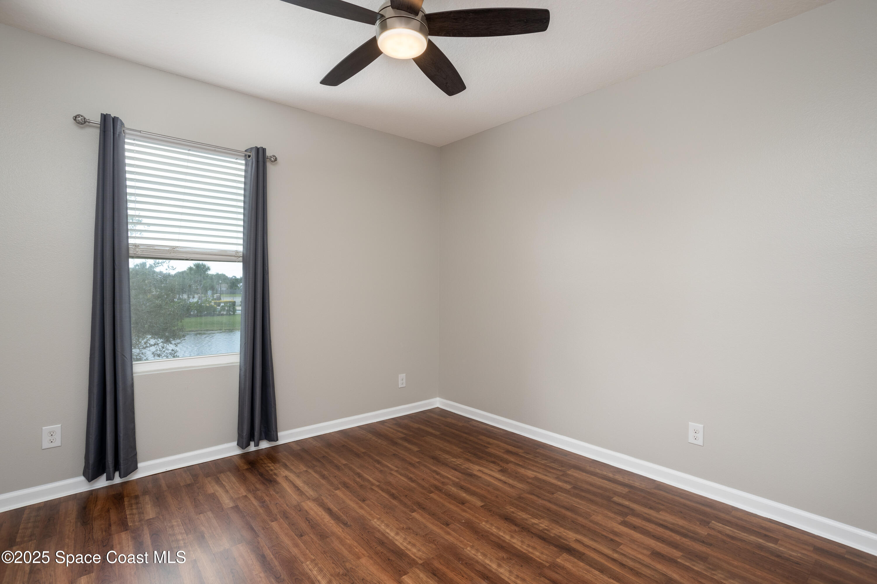 2780 Reston Street, Unit 104 Melbourne, FL 32935 - Photo 18 of 29 a view of an empty room with wooden floor and a window