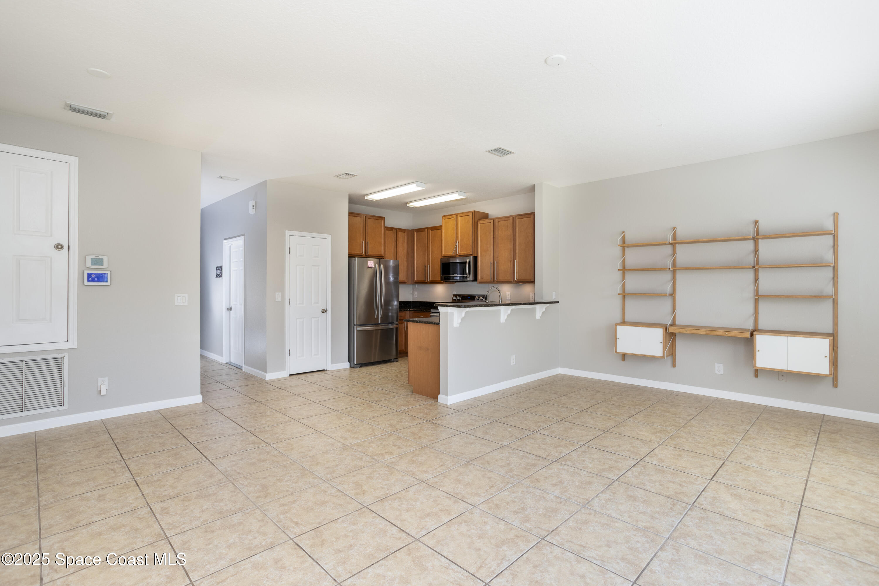 2780 Reston Street, Unit 104 Melbourne, FL 32935 - Photo 4 of 29 a view of a kitchen with cabinet and a refrigerator