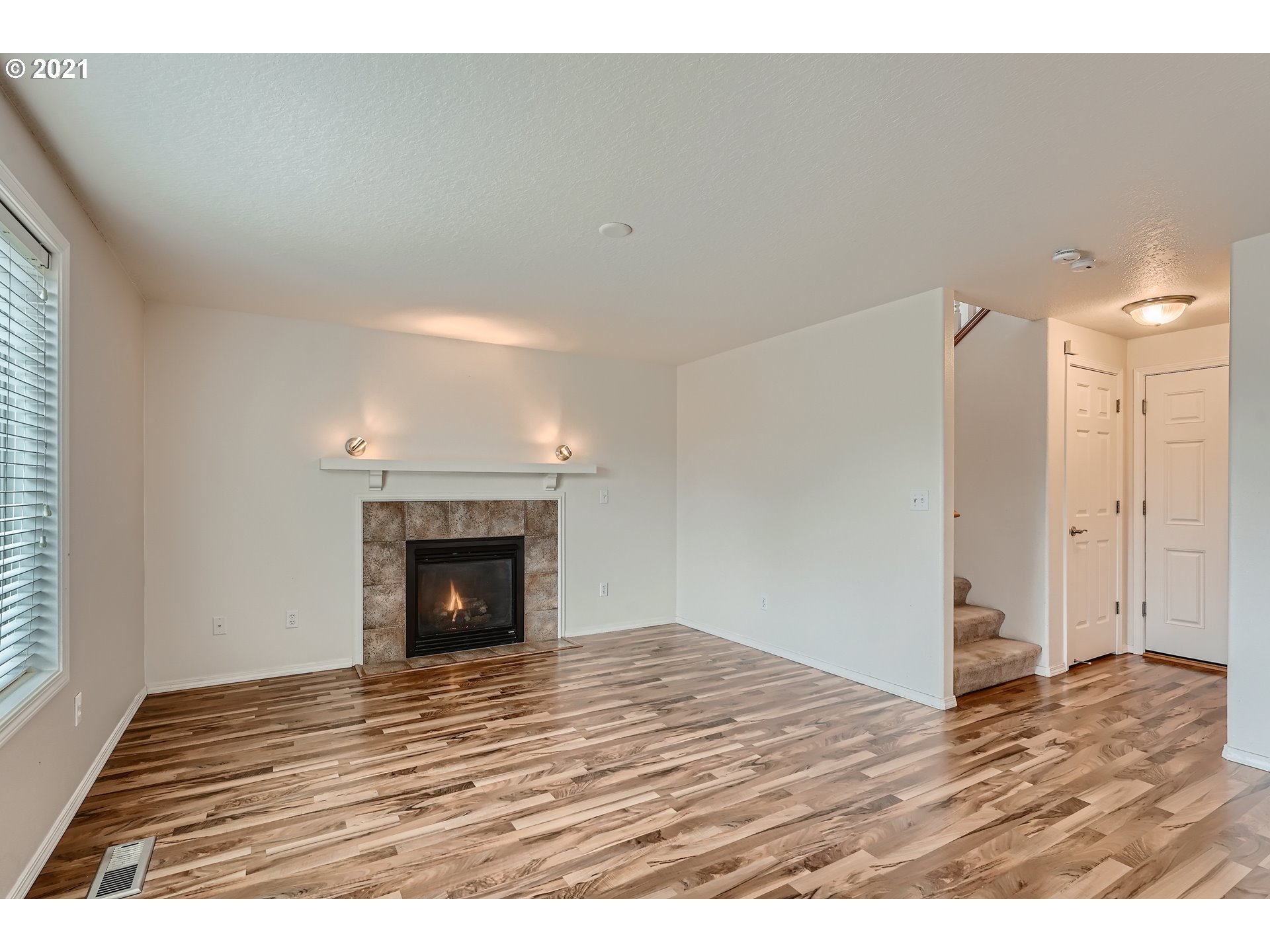 2417 North 9th Circle Ridgefield, WA 98642 - Photo 13 of 32 a view of an empty room with wooden floor fireplace and a window