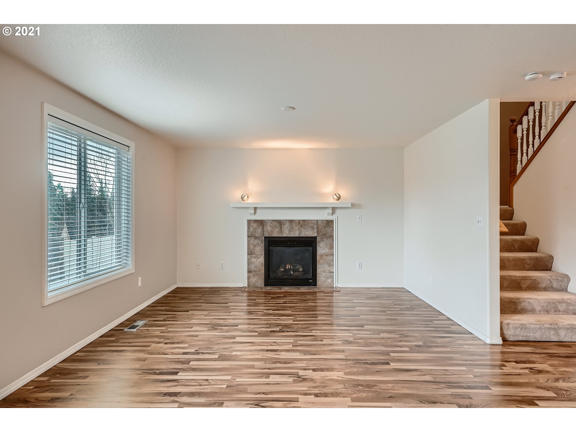 2417 North 9th Circle Ridgefield, WA 98642 - Photo 14 of 32 a view of an empty room with wooden floor fireplace and a window