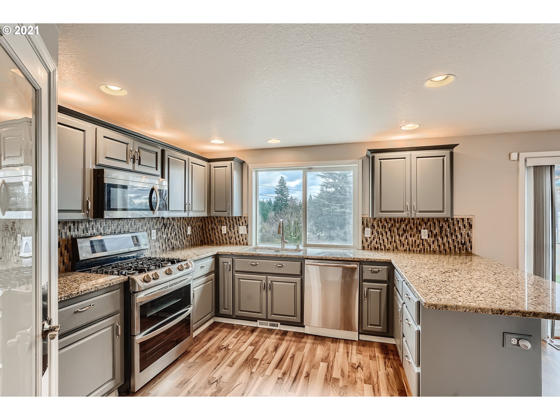 2417 North 9th Circle Ridgefield, WA 98642 - Photo 6 of 32 a kitchen with stainless steel appliances granite countertop a stove a sink and a refrigerator