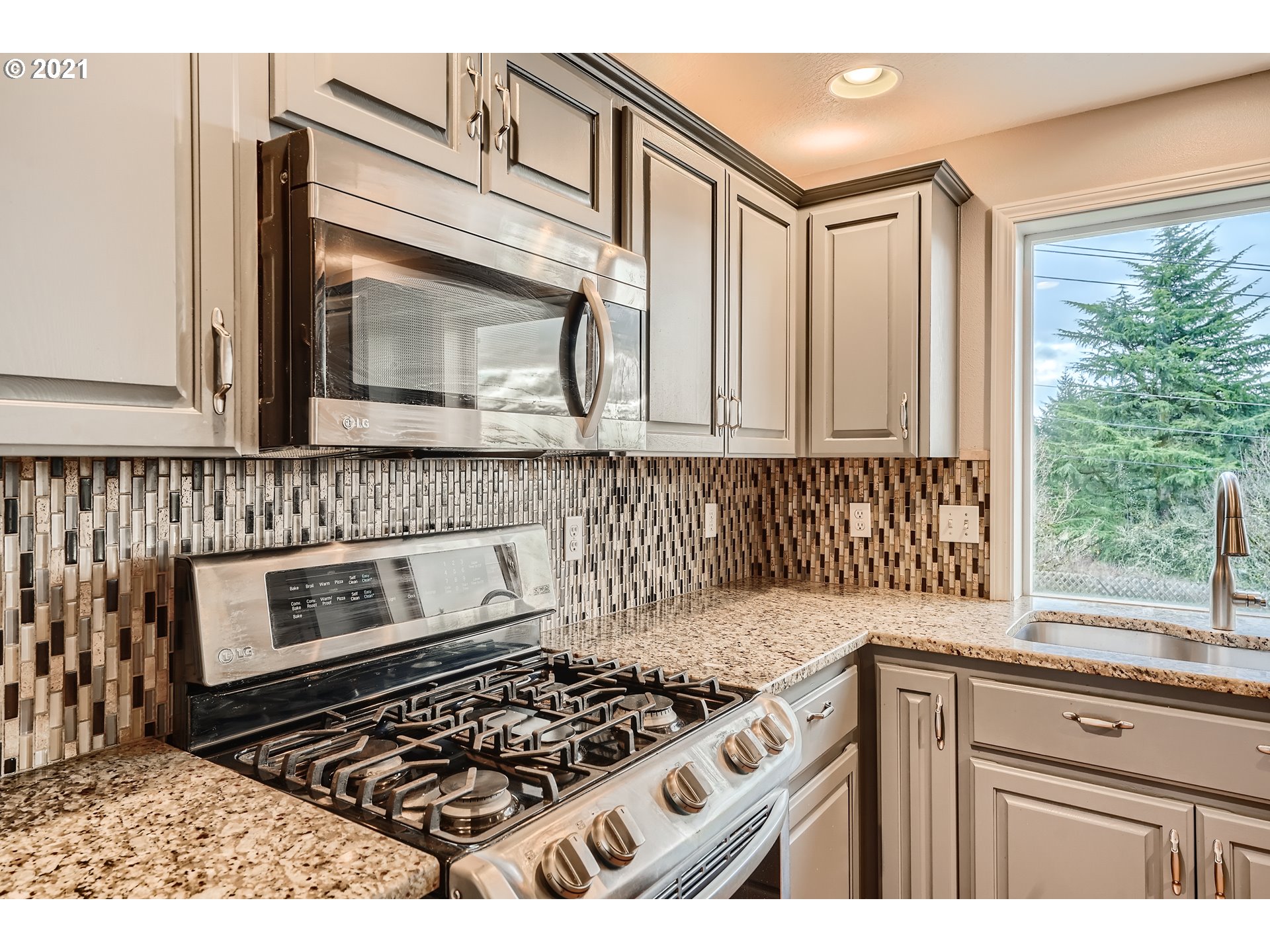 2417 North 9th Circle Ridgefield, WA 98642 - Photo 8 of 32 a kitchen with granite countertop a stove top oven cabinetry a sink and a window