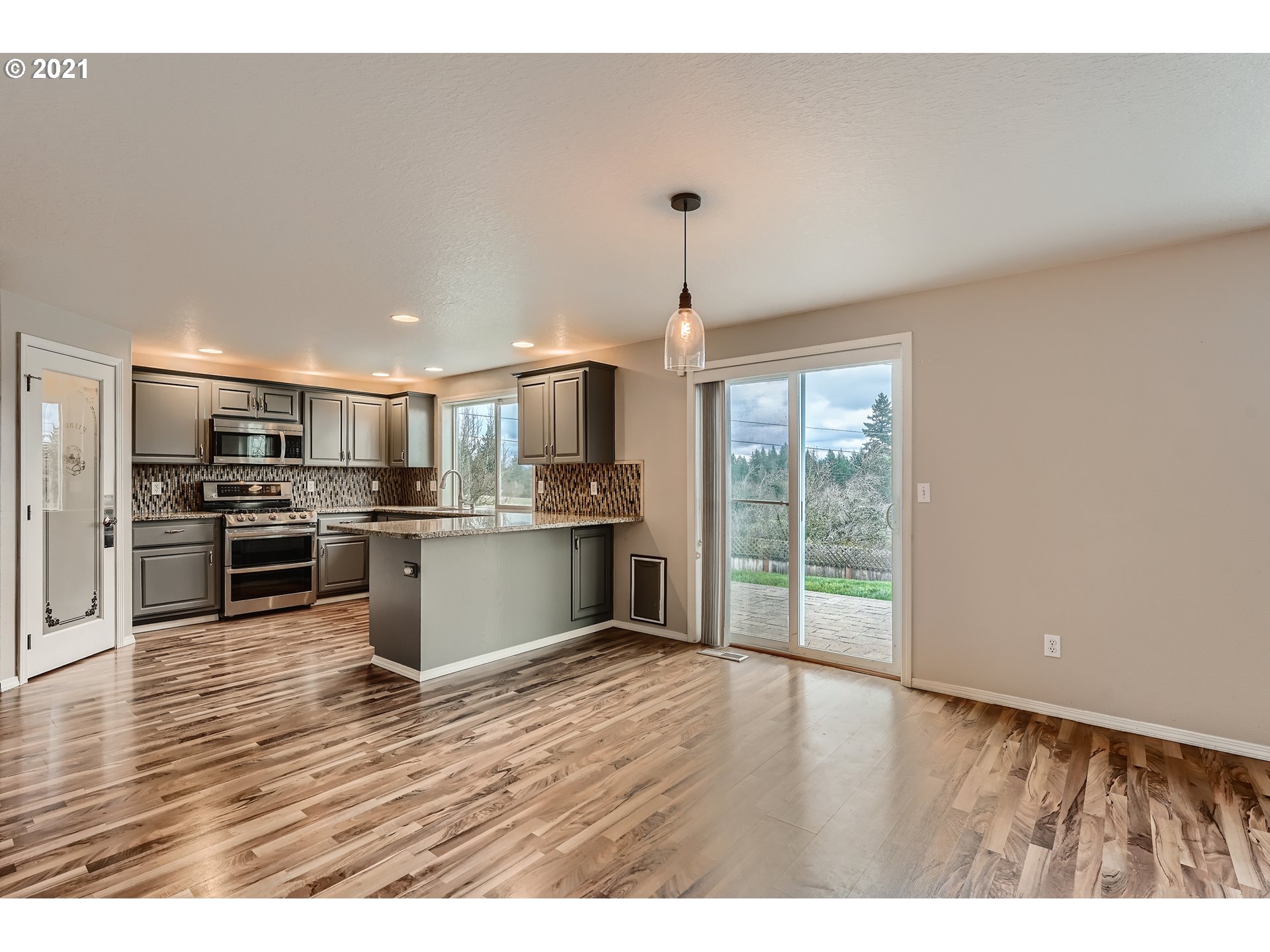 2417 North 9th Circle Ridgefield, WA 98642 - Photo 10 of 32 a open kitchen with kitchen island white cabinets and refrigerator