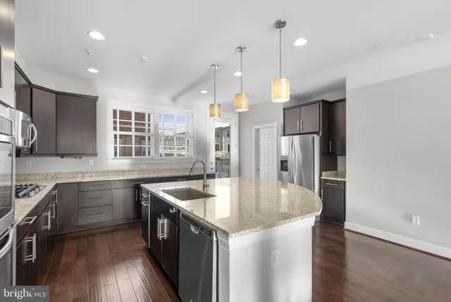 a kitchen with stainless steel appliances granite countertop a sink a oven and a refrigerator