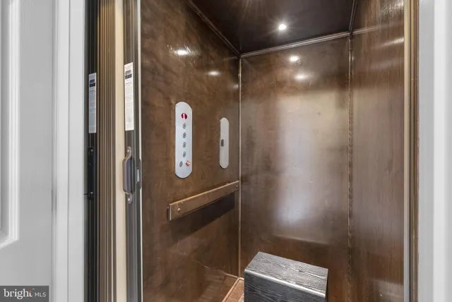 a front view of a building with lot of cars parked on road and lamp